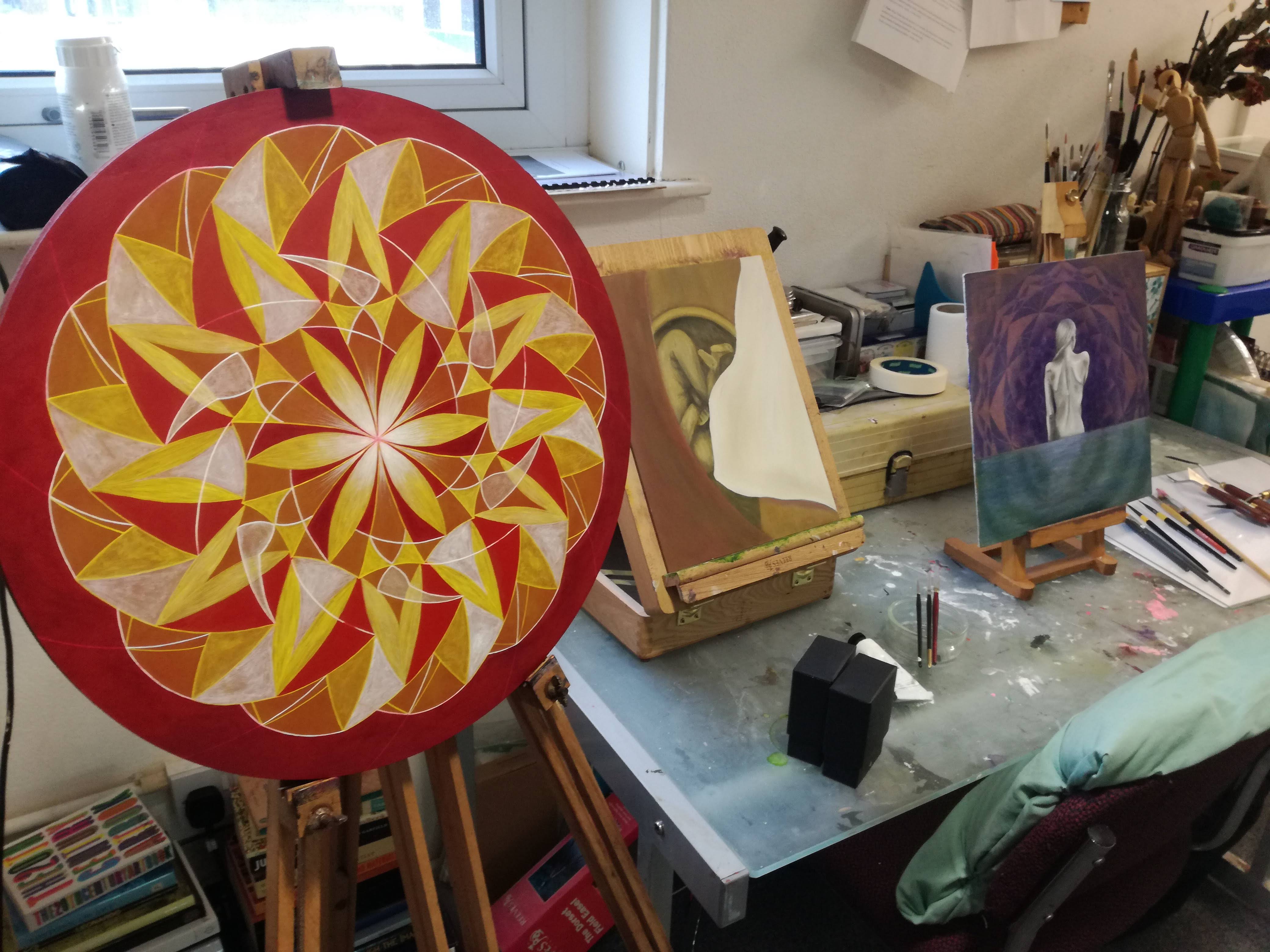 Image of a studio desk featuring a mandala painting by the artist Lily Karen